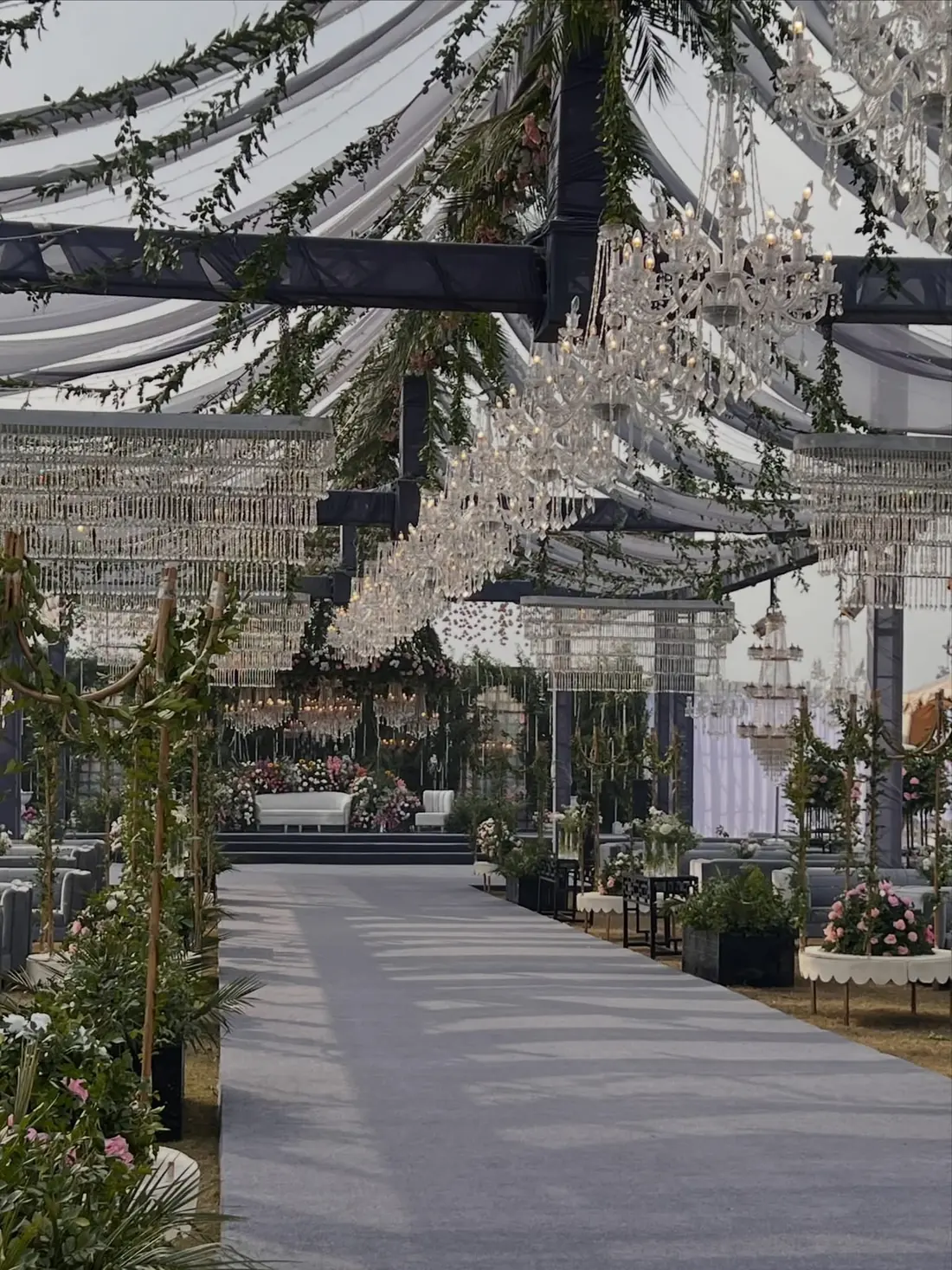 Garden tent aisle with hanging chandeliers by Events by OT